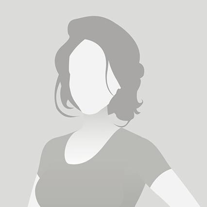 Profil einer Frau mit lockigem Haar, die in einem T-Shirt steht und den Oberkörper leicht zur Seite neigt.